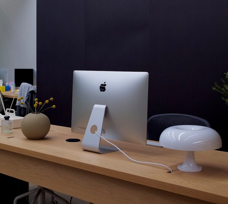 Um Computador Apple Sentado Em Cima De Uma Mesa De Madeira ExGZwOS5sFA